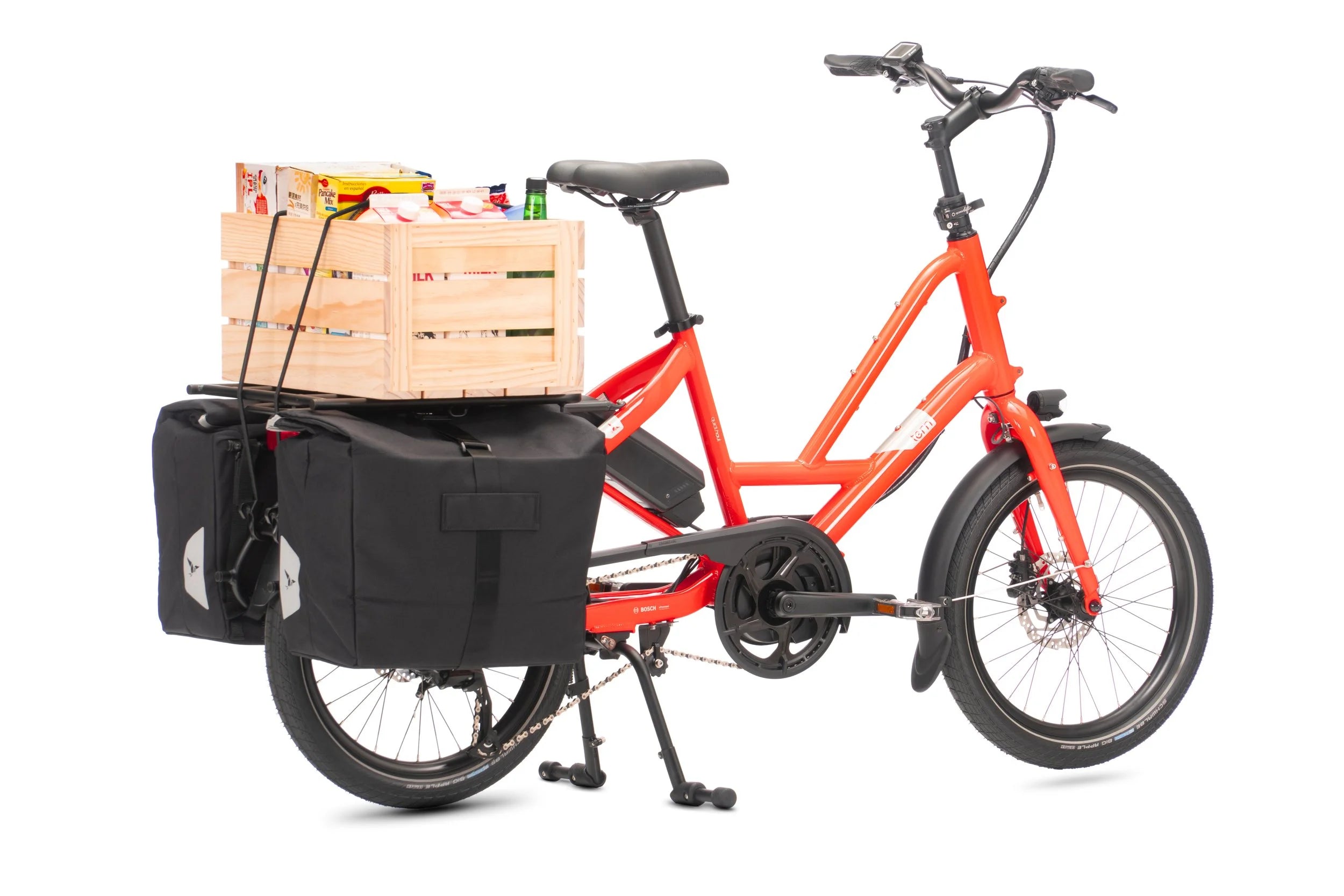 Orange cargo bike with a wooden crate and black panniers on a white background