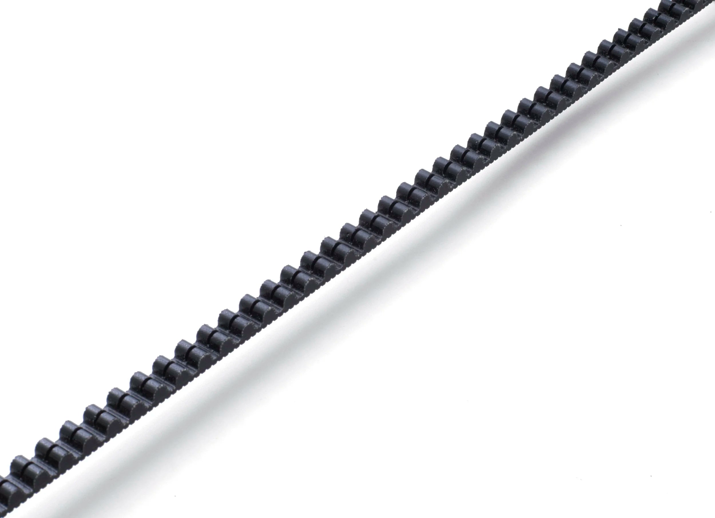 A section showing the teeth of a Gates Carbon Drive belt drive on a white background