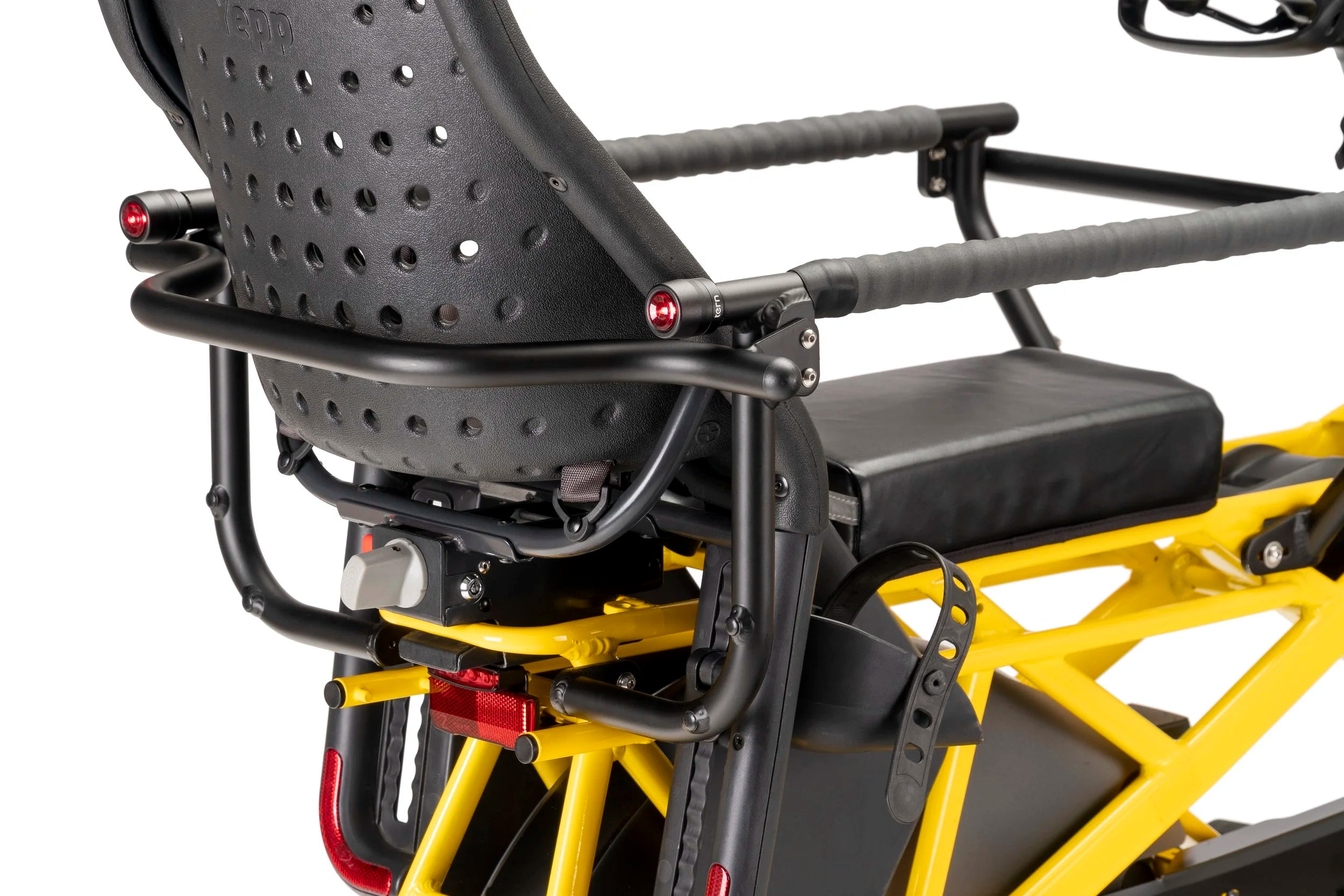 Close-up of a bicycle seat with a black perforated design and yellow frame.