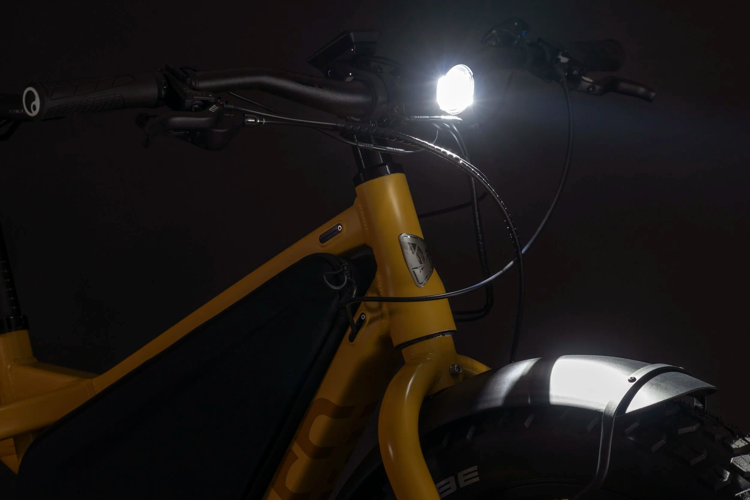 Yellow bicycle with a headlight on in a dark setting