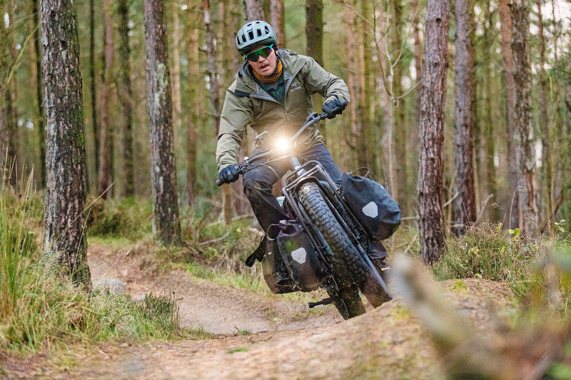 Person riding a fat bike through a forest