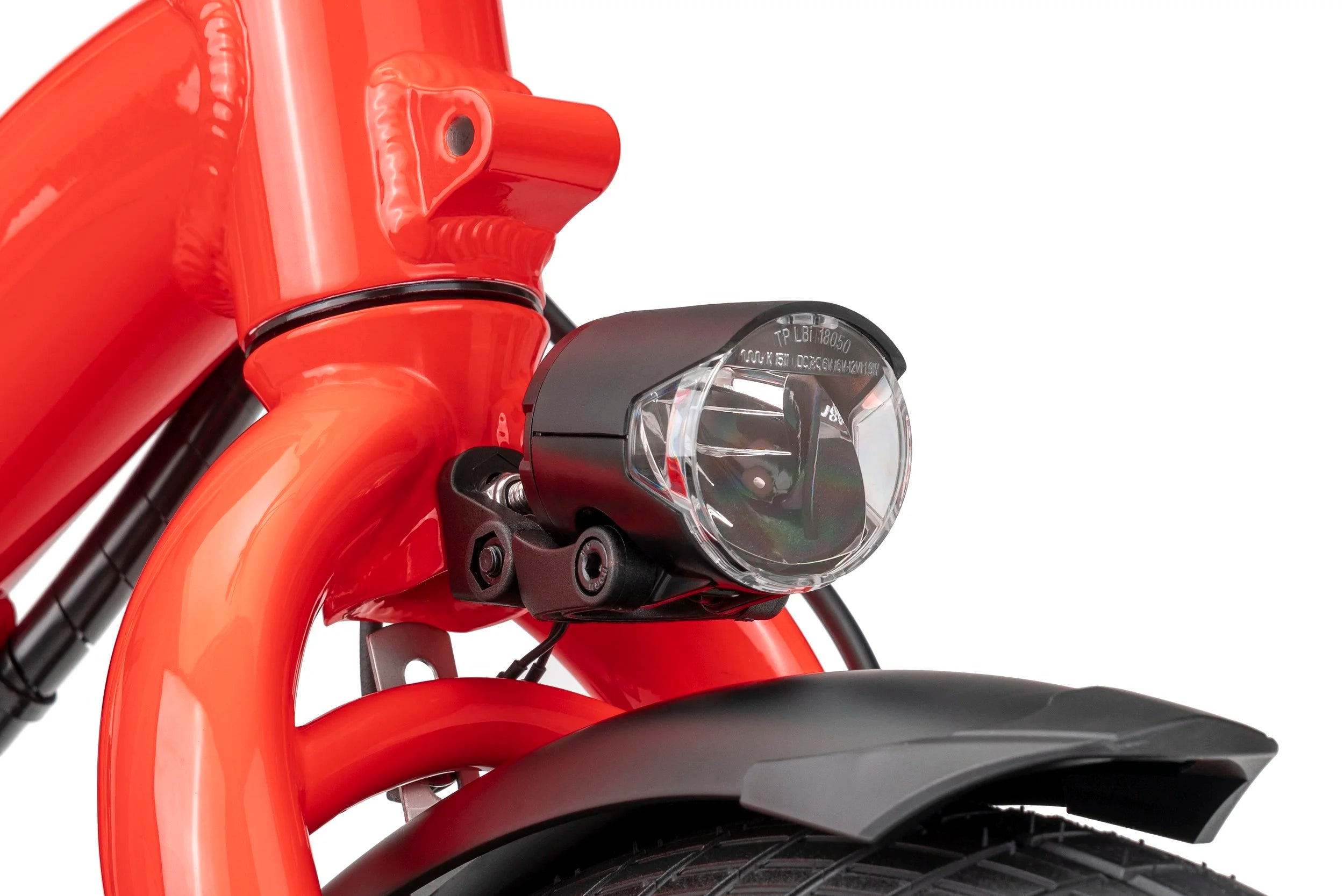 Close-up of a red bicycle headlight and front fork on a white background