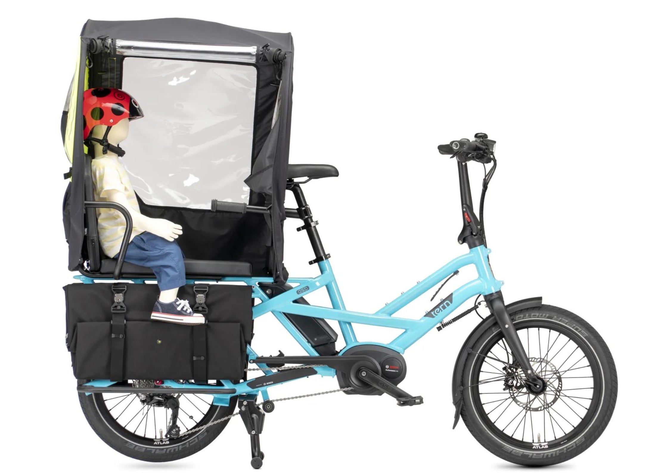 A blue Tern cargo bike with a child carrier with a rain cover.