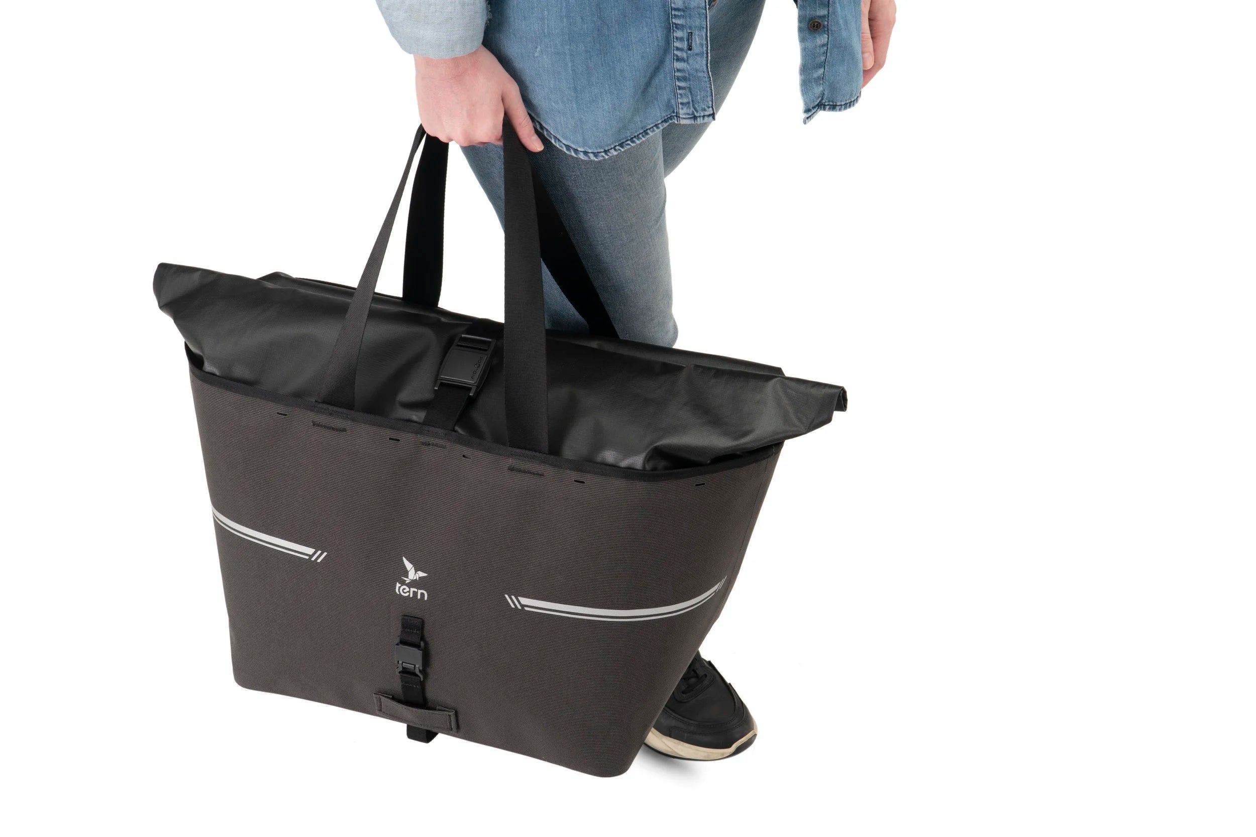 Person holding a black bike carrier bag on a white background