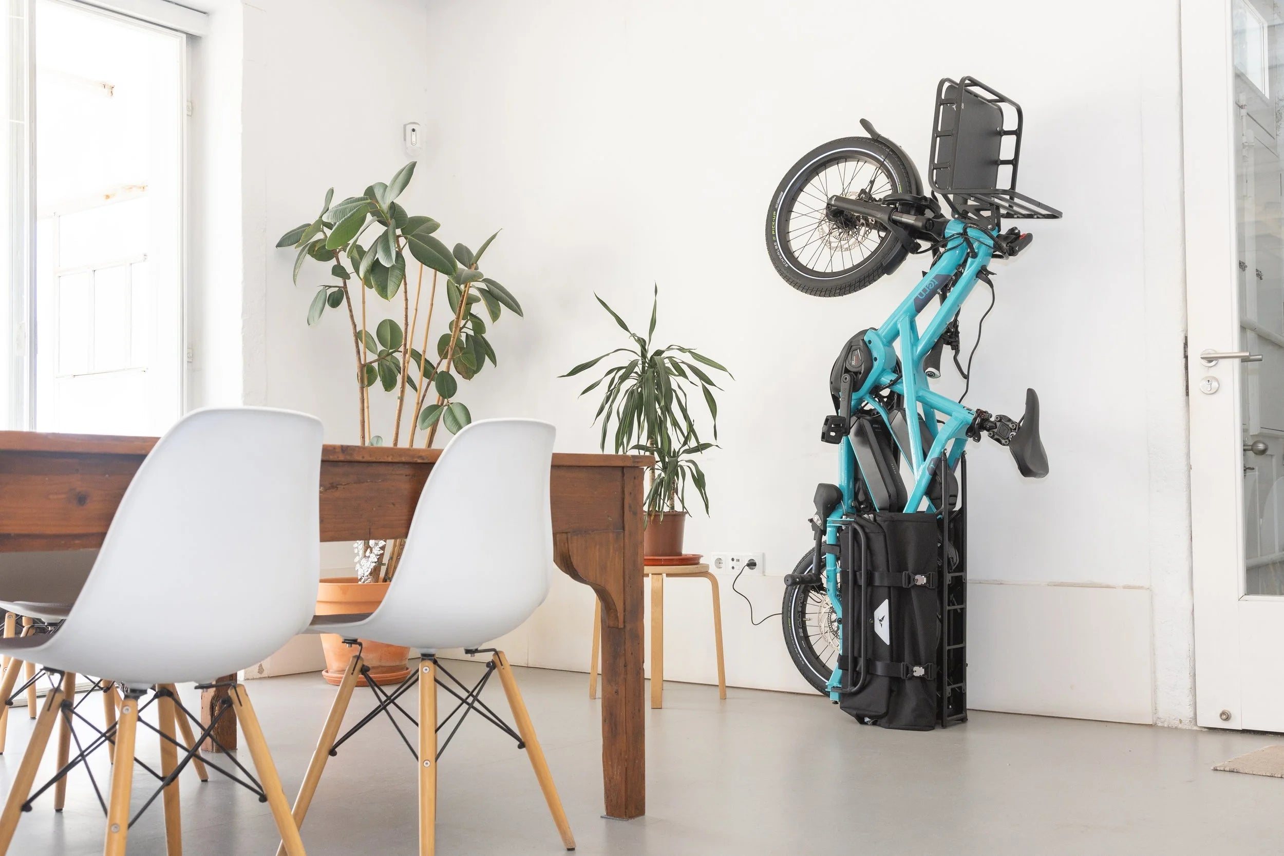 Foldable Tern electric bike against a white wall with a modern interior setting.