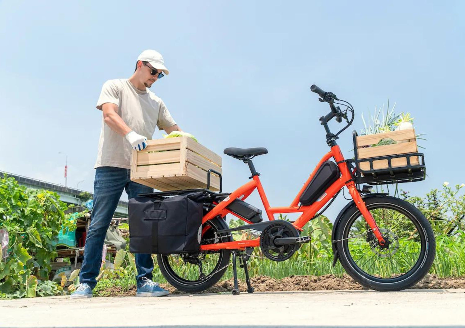 A person loading a tern cargo bike with wooden crates.