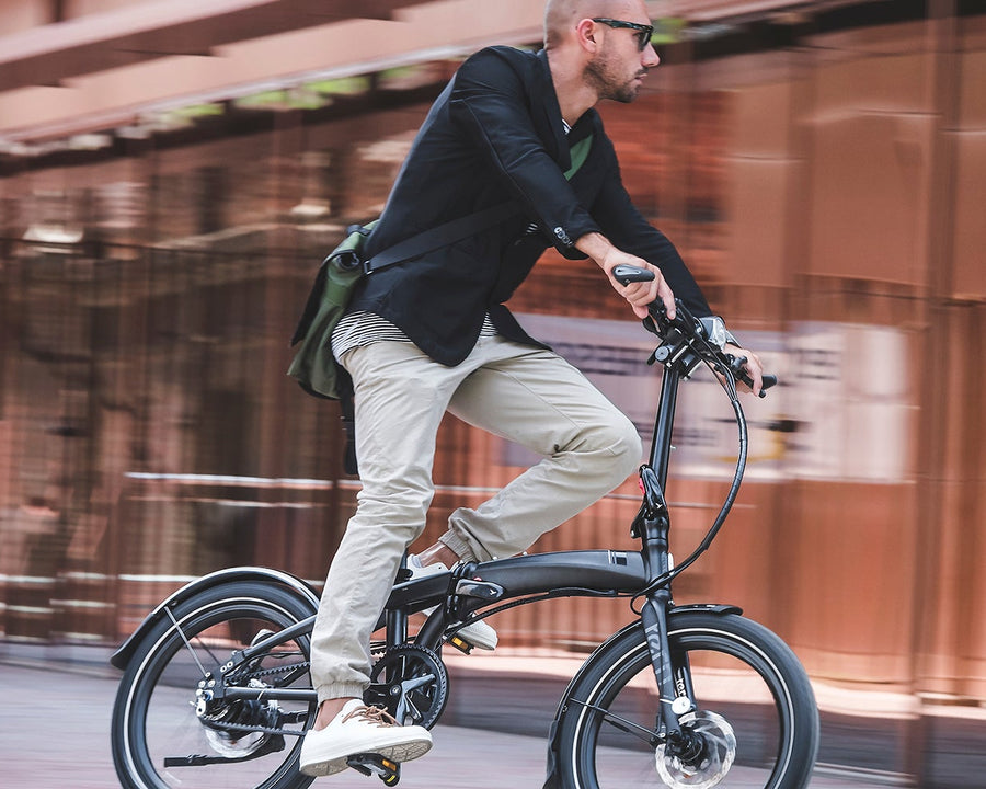 Person n a Tern Verge folding bike n a blurred background.
