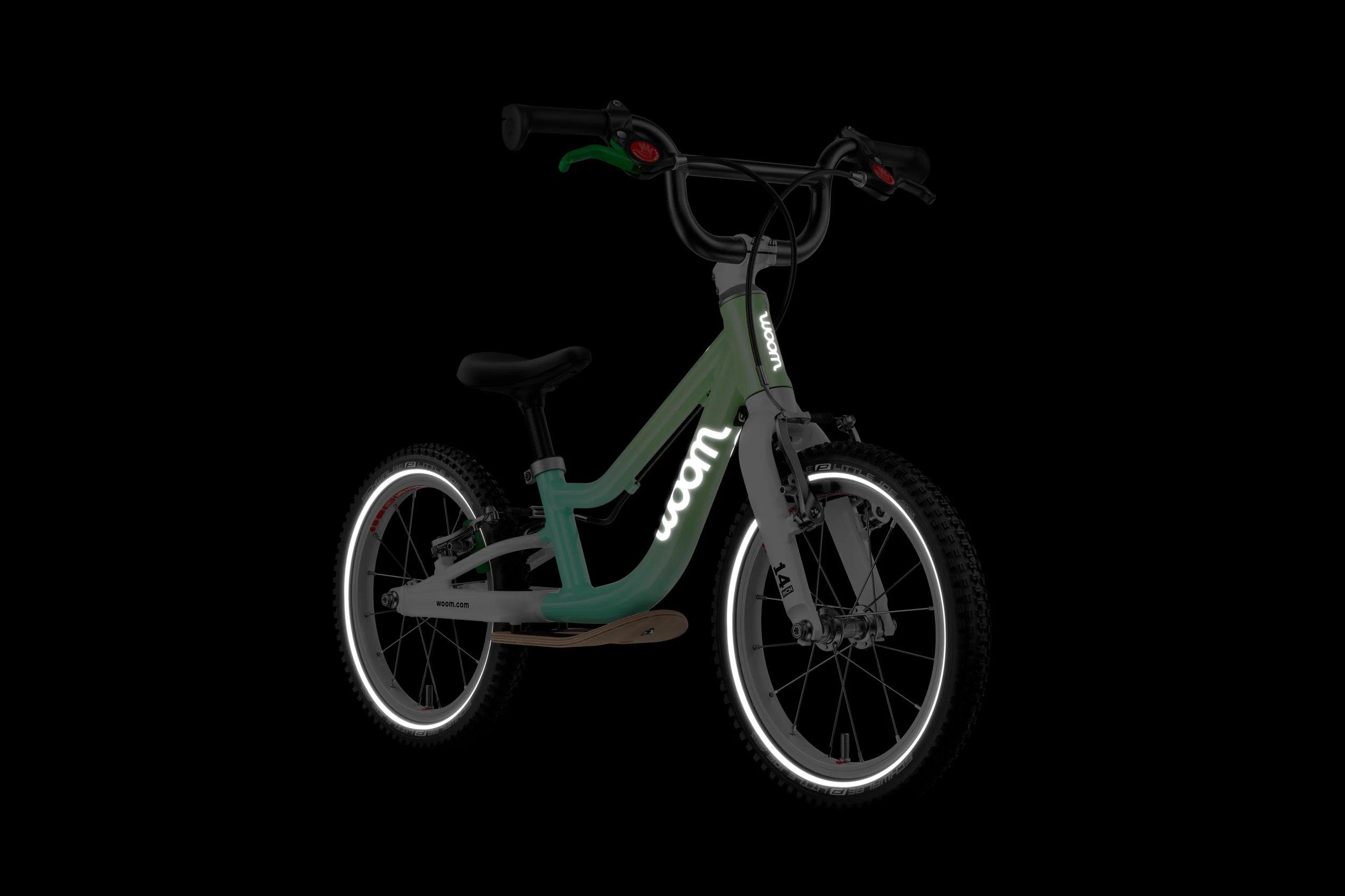 Children's balance bike with reflective details on wheels and frame on a black background