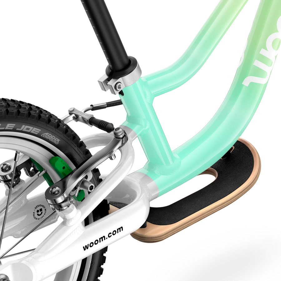 Close-up of a woom children's bike with a gradient green frame on a white background