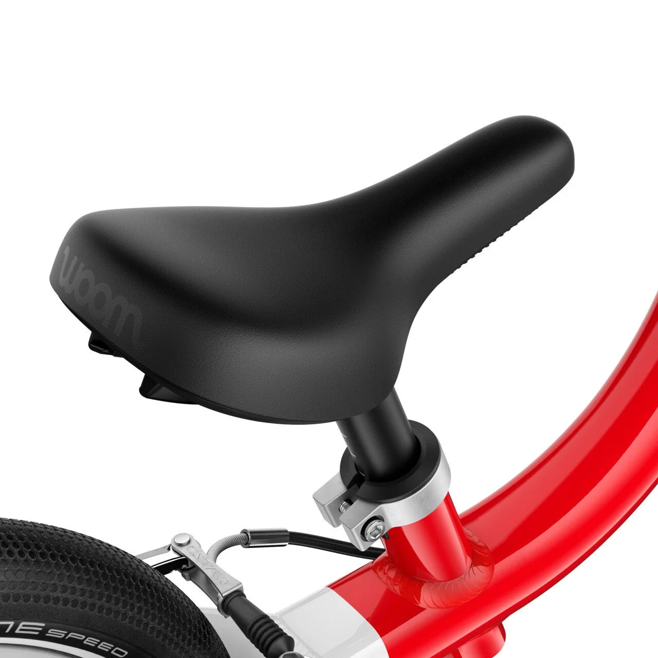 Close-up of a black bicycle seat on a red frame with 'woom' branding.