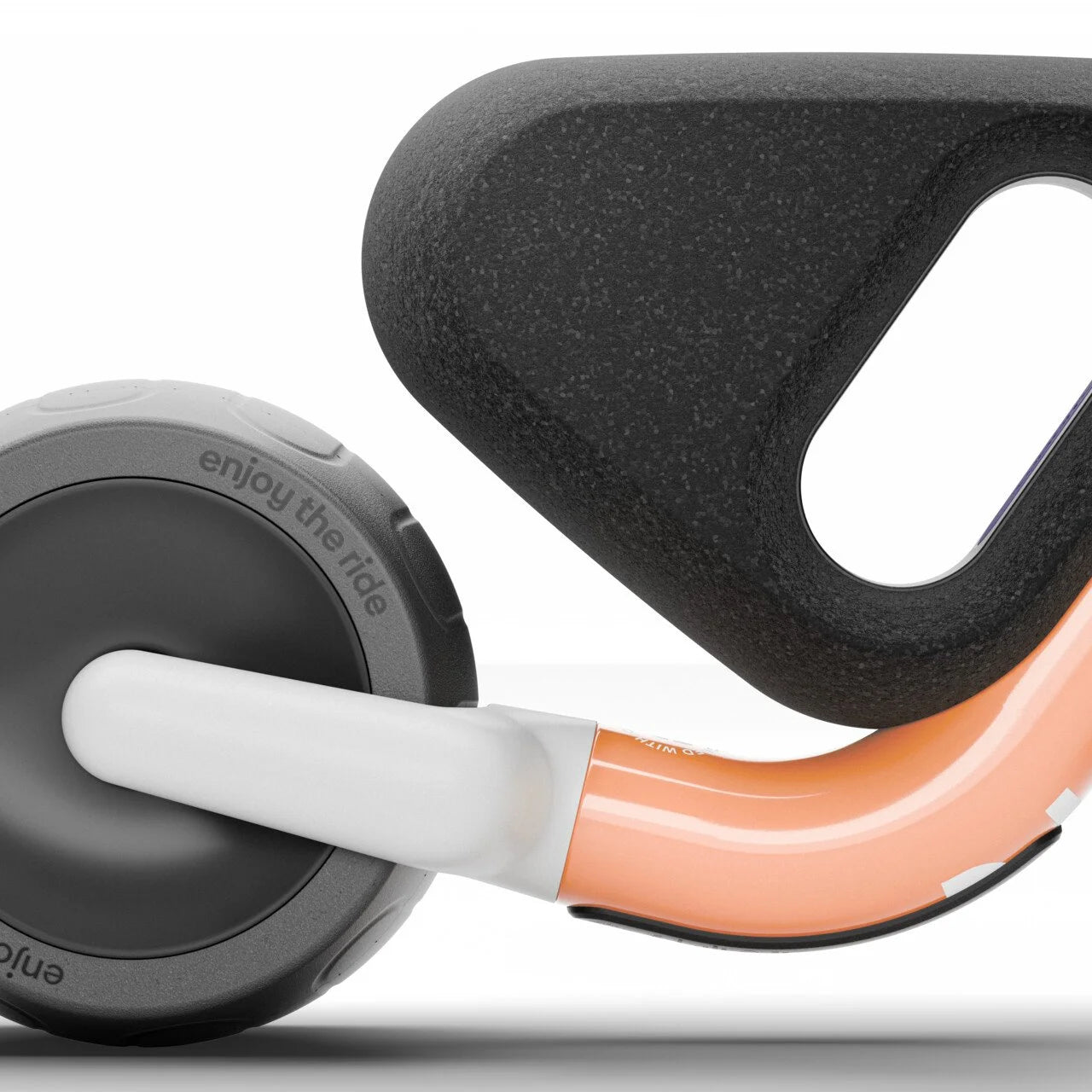 Close-up of a Woom balance bike handlebar with black grip and orange and white accents on a white background.
