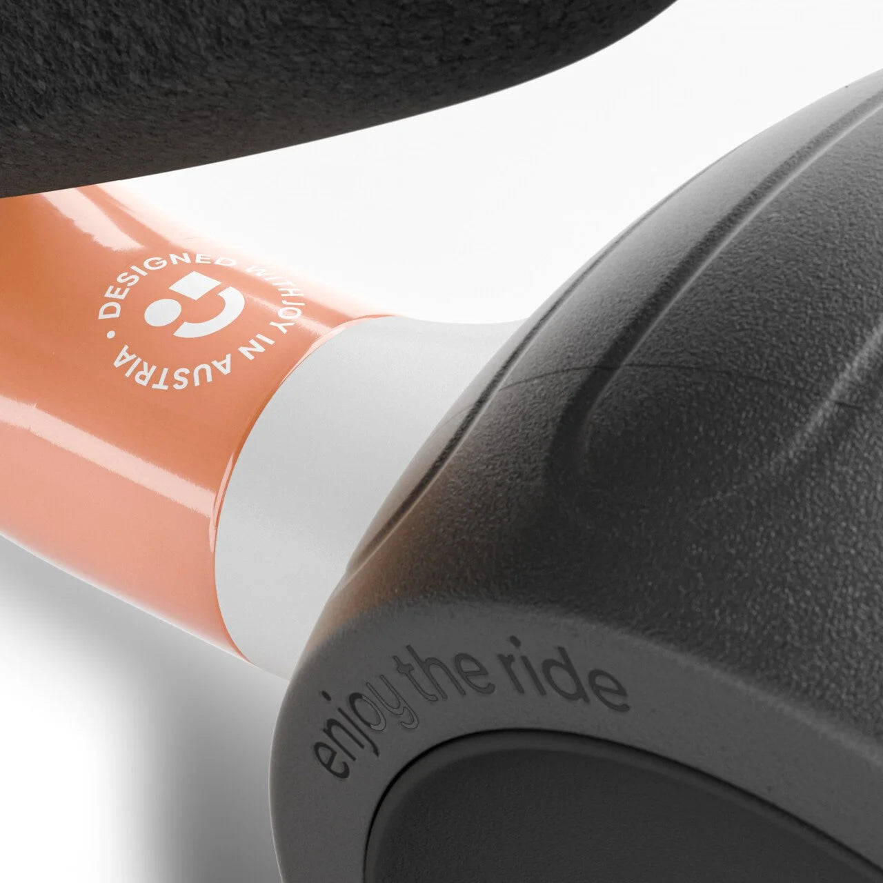 Close-up of a Woom bicycle handlebar with 'enjoy the ride' text and a brand logo.