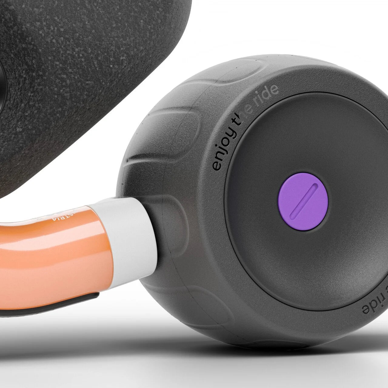 Close-up of a black and orange Woom balance bike wheel with a purple detail on a white background