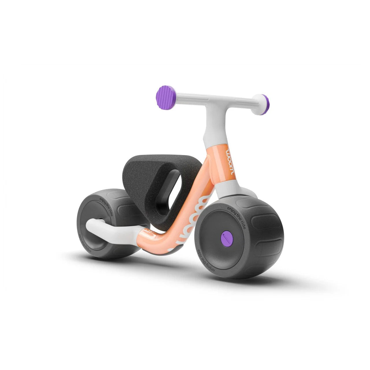 Children's Woom balance bike with orange frame and black tyres on a white background