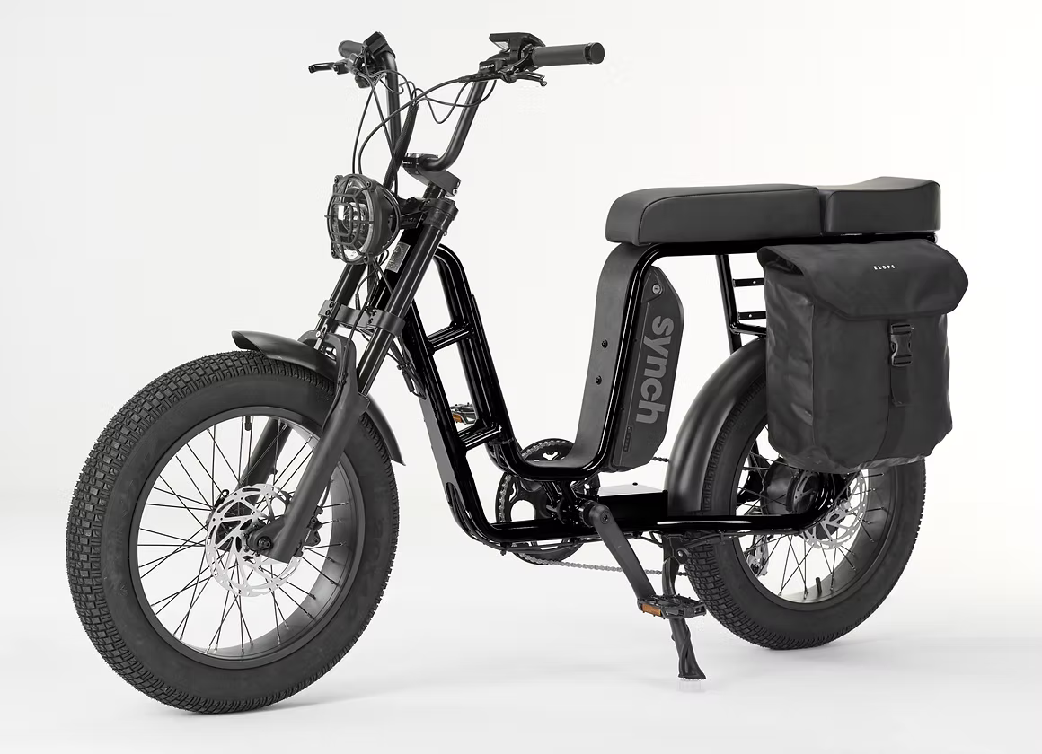 A black electric bicycle with fat tires, a step-through frame, a rear cargo bag, and a rear passenger platform, shown on a clean white studio background.