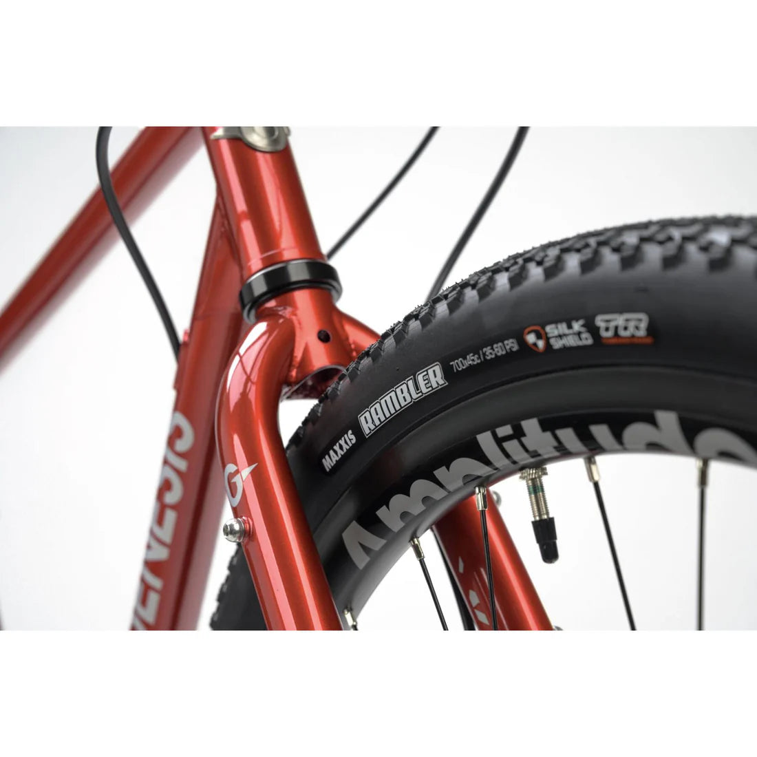 Close-up of a red bicycle frame with a Maxxis tire on a white background