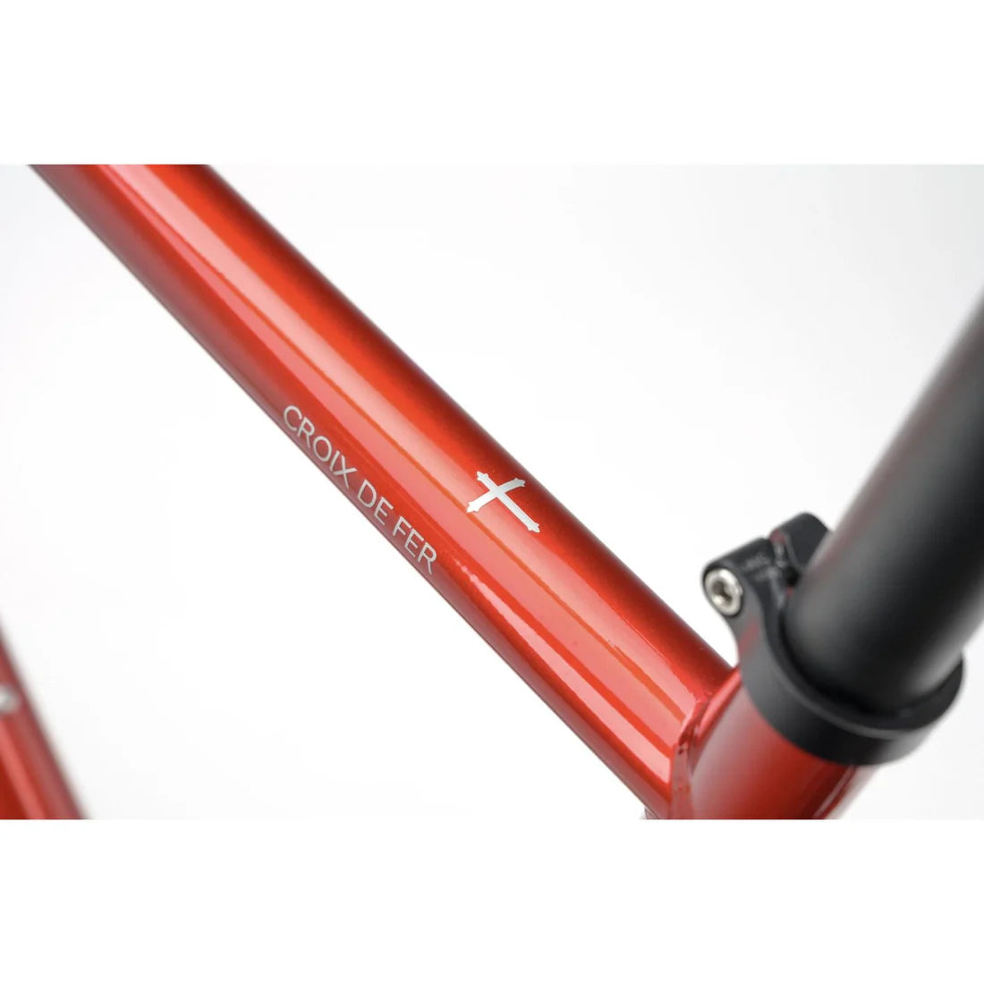Close-up of a red bicycle frame with 'Croix de Fer' branding on a white background