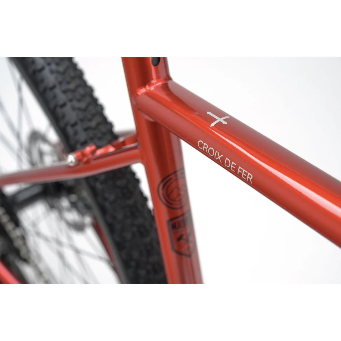 Close-up of a red bicycle frame with 'Croix de Fer' branding on a white background