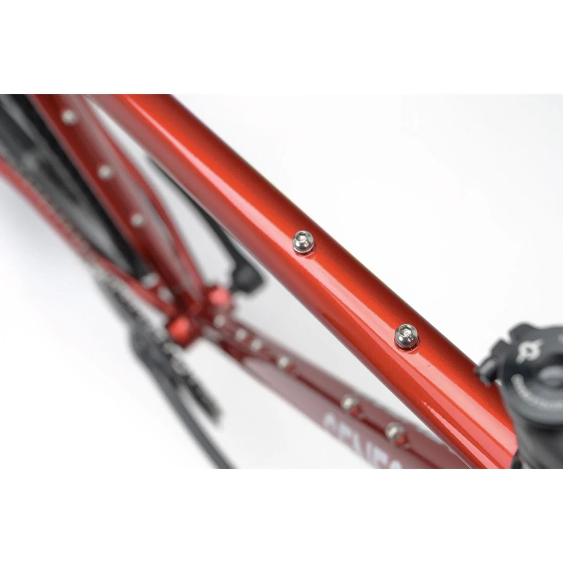 Close-up of a red bicycle frame with visible branding on a white background