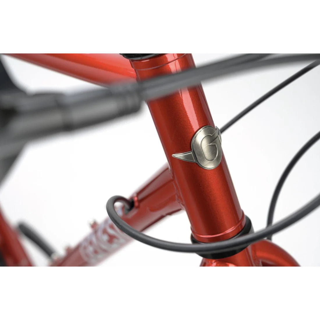 Close-up of a red bicycle frame with a brand logo on a white background