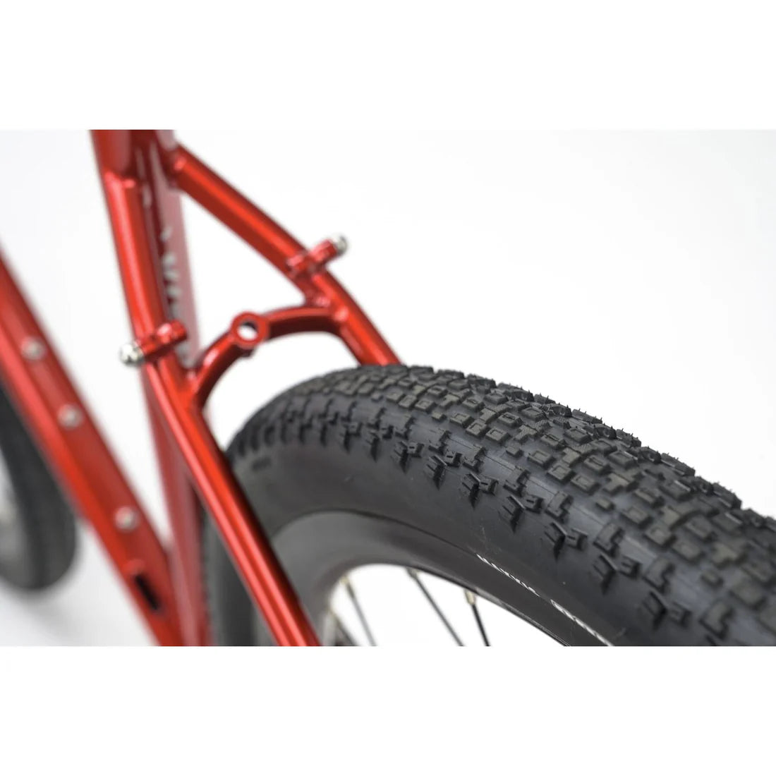 Close-up of a red bicycle frame and black tire on a white background