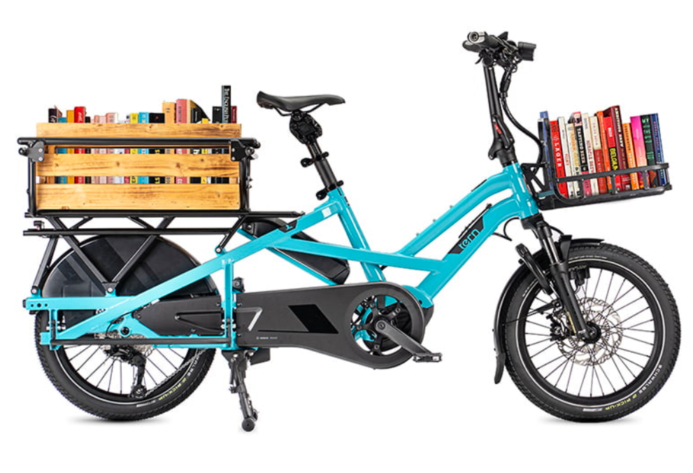 Blue cargo bike with wooden crate and book baskets on a white background