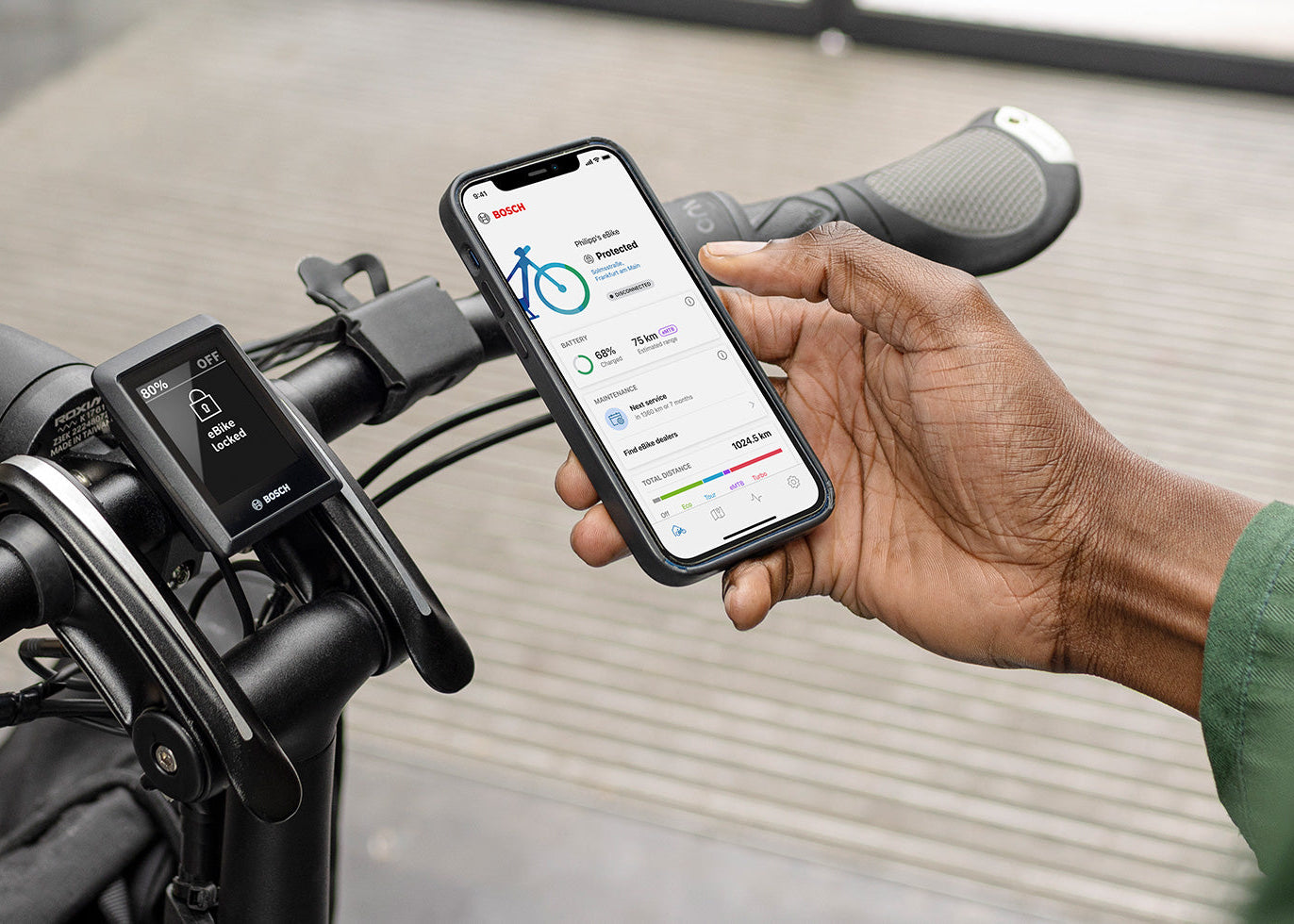 Person using a smartphone app on an electric bike with a blurred background