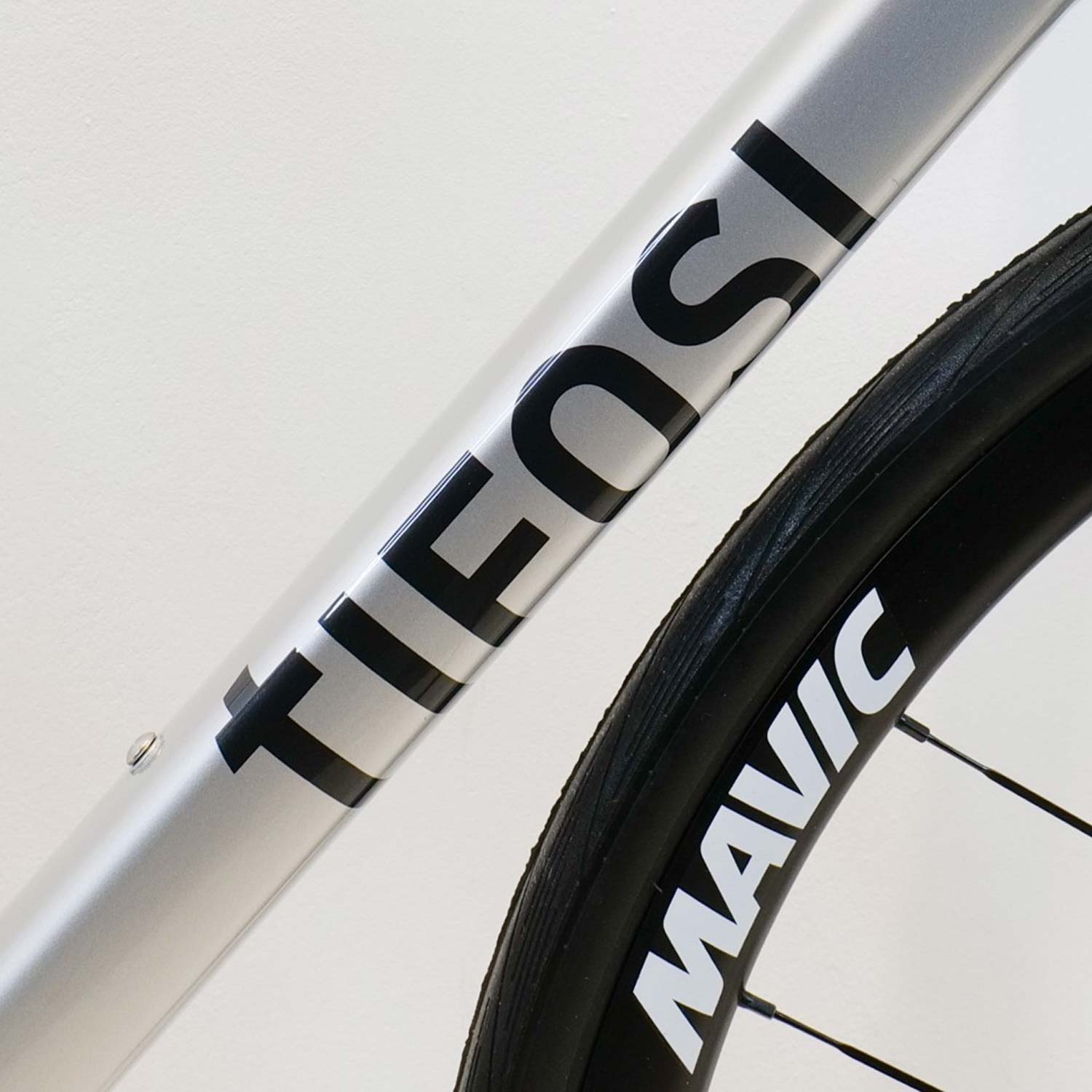 Silver bicycle frame with Tifosi branding on it on a white background